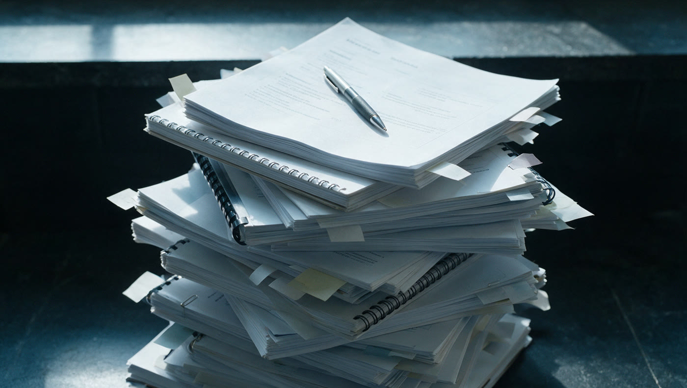 A desk stacked with inbound reading